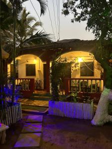 a house with purple lights in front of it at Prakriti Resort in Arambol