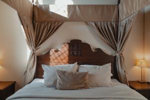 ein Schlafzimmer mit Himmelbett und weißen Kissen in der Unterkunft Monte Pacis Hotel In Pažaislis in Kaunas