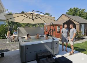 a group of people in a hot tub with an umbrella at Come As You Are Inn LLC in Sayville