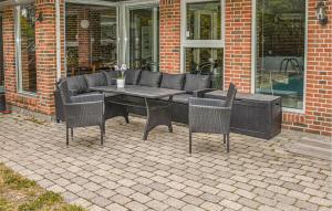 a patio with a table and chairs on a brick building at Nice Home In Højby With Sauna in Højby
