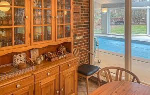 a dining room with a wooden cabinet and a table at Nice Home In Højby With Sauna in Højby