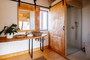 a bathroom with a sink and a mirror and a shower at Herdade da Maceira in São Luis