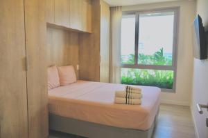 a small bedroom with a bed with a window at Lujoso Departamento con Garage in Caña de Castilla +15 photos