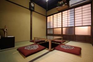 a room with a table and two red mats at Guest House Ui-ca in Kanazawa