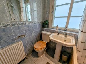 a bathroom with a toilet and a sink at City Center Gem-4Bd House! in Edinburgh
