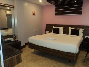 a bedroom with a large bed and a mirror at Mani's residency in Madurai