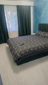 a large bed in a bedroom with green curtains at DNY Home 2 in Giurgiu