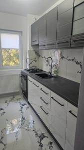 a kitchen with white cabinets and a sink and a window at DNY Home 2 in Giurgiu