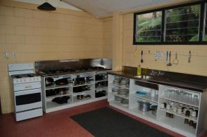 a kitchen with a stove and a counter with appliances at Egmont Eco Leisure Park & Backpackers in New Plymouth