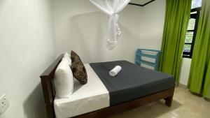 a bedroom with a bed and a blue chair at Friendship Villa-Ella in Nikawatawana +30 photos