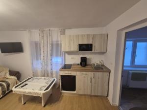 a small kitchen with a counter and a table in a room at Hello Retezat in Râu de Mori