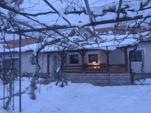 a house with a fire in the window in the snow at Hello Retezat in Râu de Mori