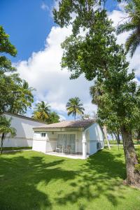 ein weißes Haus mit einem Baum im Garten in der Unterkunft Blue JackTar in San Felipe de Puerto Plata