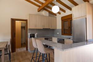 a kitchen with a counter with chairs and a refrigerator at YourHouse Casa Canastro in Allariz +8 photos