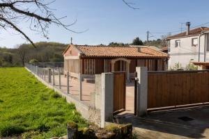 a house with a fence next to a field at YourHouse Casa Canastro in Allariz