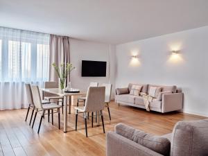 a living room with a table and chairs and a couch at Apartamenty Media Park in Warsaw