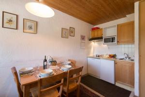 a kitchen with a wooden table with chairs and a tableablish at Résidence Igloo in Le Tour