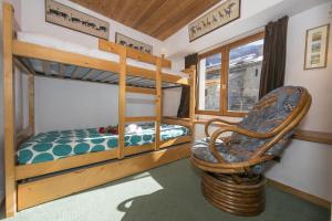 a bunk bed room with two bunk beds and a chair at Résidence Igloo in Le Tour