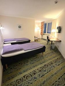 a hotel room with two beds and a desk at Hotel Pause - Free WiFi & Free Parking!! in Hofheim am Taunus