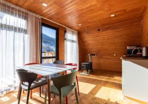 a kitchen and dining room with a table and chairs at Rock Cabins Svaneti in Mestia