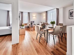 a living room and dining room with a table and chairs at Apartamenty Media Park in Warsaw