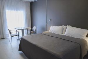 a bedroom with a bed and a table with chairs at HDA Miraflores in Termas de Río Hondo