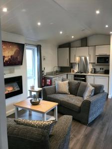 a living room with a couch and a table at Finest Retreats - Silverwood Hideaway Lodge in Errol