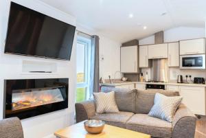 a living room with a couch and a fireplace at Finest Retreats - Silverwood Hideaway Lodge in Errol +3 photos