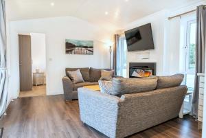 a living room with a couch and a fireplace at Finest Retreats - Silverwood Hideaway Lodge in Errol