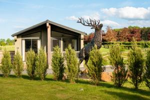 a statue of a giraffe in front of a house at Finest Retreats - Silverwood Hideaway Lodge in Errol