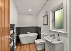 a bathroom with a tub and a toilet and a sink at Finest Retreats - Silverwood Deluxe Chalet in Errol +5 photos