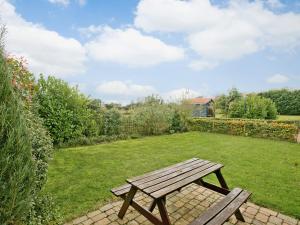 ein hölzerner Picknicktisch steht in einem Garten in der Unterkunft Oregano - E4483 in Catfield