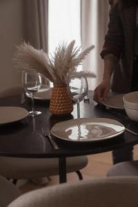 a table with a plate and wine glasses on it at Sézam Appart’Hôtel Saint-Malo in Saint Malo +59 photos