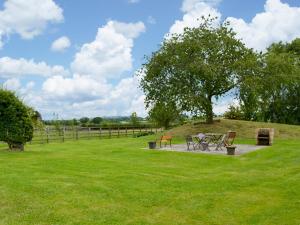 a picnic table in a field with a tree at Bilsdale - 25566 in Nether Silton