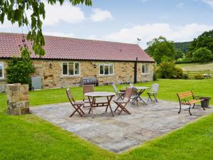 a patio with chairs and tables in front of a building at Bilsdale - 25566 in Nether Silton +3 photos