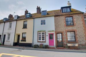 a row of houses with a pink door on a street at 4 Bed in Rottingdean oc-bbrott in Rottingdean