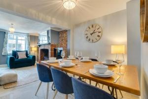 a dining room with a table and chairs and a clock at 4 Bed in Rottingdean oc-bbrott in Rottingdean