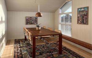 a dining room with a wooden table and chairs at Amazing Home In Juelsminde With House Sea View in Juelsminde
