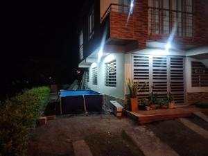 a house lit up at night with a swimming pool at Hospedaje Villa Laura in Cite