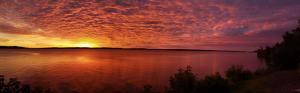 a sunset over a large body of water at Haileybury Beach Motel in Haileybury