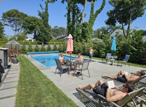 a group of people laying on lawn chairs by a pool at Come As You Are Inn LLC in Sayville