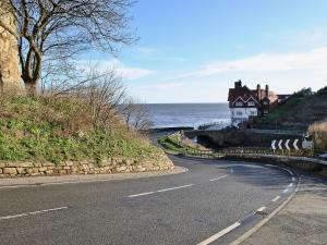 a house on the side of a hill next to the ocean at Sunnyside in Sandsend +6 photos