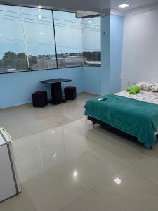 a bedroom with a bed and a table in a room at Quarto privado ótima vista próximo ao centro in Manaus