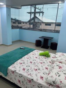 a bedroom with a bed and a table in a room at Quarto privado ótima vista próximo ao centro in Manaus