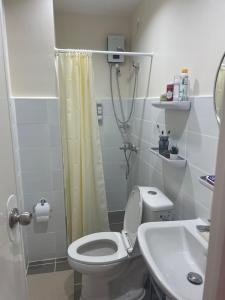 a small bathroom with a toilet and a sink at Mactan Plains condo unit in Punta Engaño