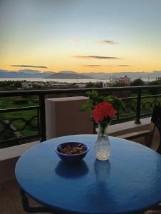 a blue table with a vase of flowers and a bowl of nuts at The house of joy in Egina