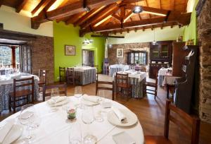 a dining room with white tables and chairs at La Rectoral in Taramundi