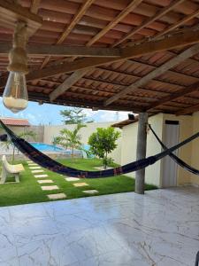 a hammock on a patio with a yard at Espaço Recanto Del Mar in Paracuru