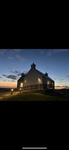 a large white house with a fence in front of it at Lighthouse View in Lochboisdale