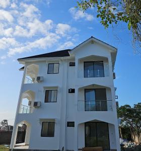 a white building with windows on the side of it at Upole HOTEL in Nungwi +71 photos